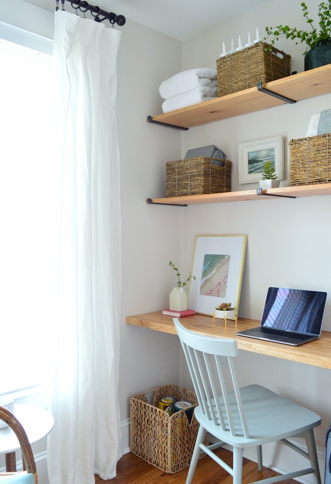 Office Nook Created In Small Room With Floating Wood Shelves And Desk With Laptop Computer