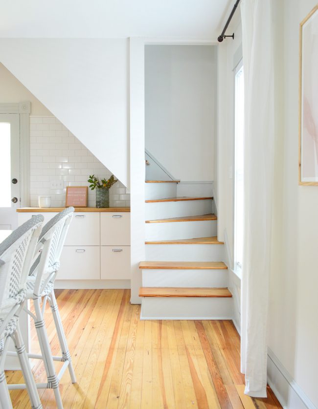 After Photo Of Rear Staircase In Historic Beach House With Tile Backsplash and Kitchen Cabinets Nearby