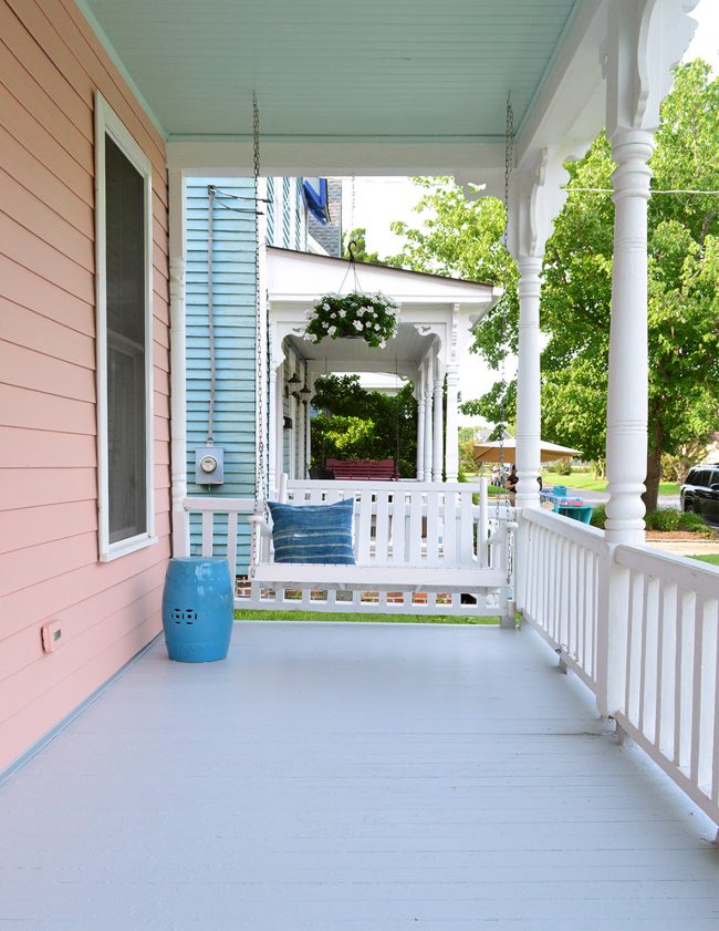 After Photo Of Beach House Porch With Mellow Coral Siding And White Porch Swing