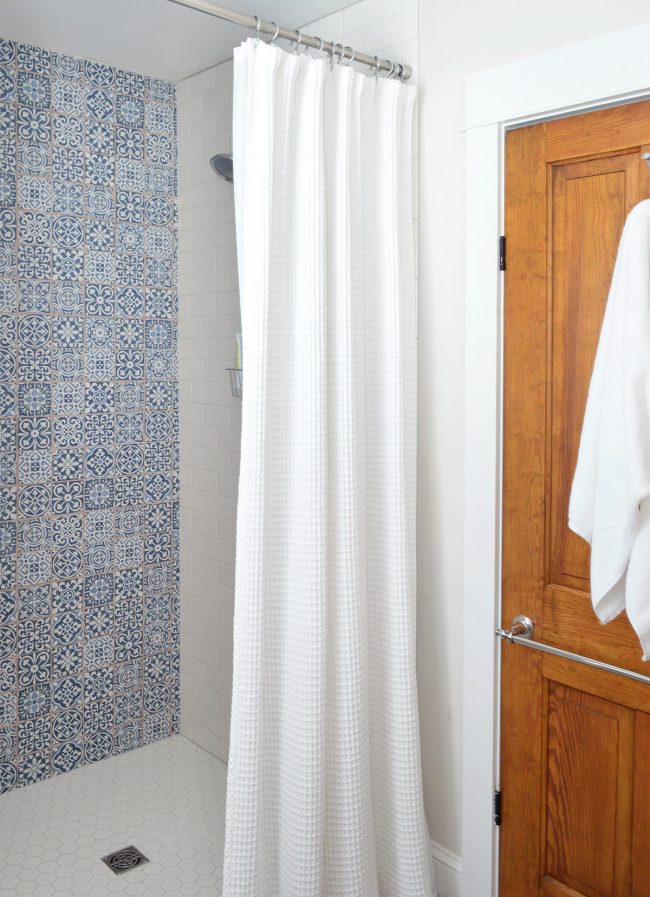View Into Beach House Hall Bathroom Shower With Pattern Blue Tile Accent Wall