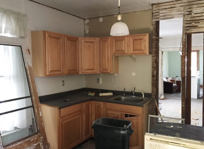 Before Photo Of Beach House Kitchen With Cabinets On Crumbling Wall