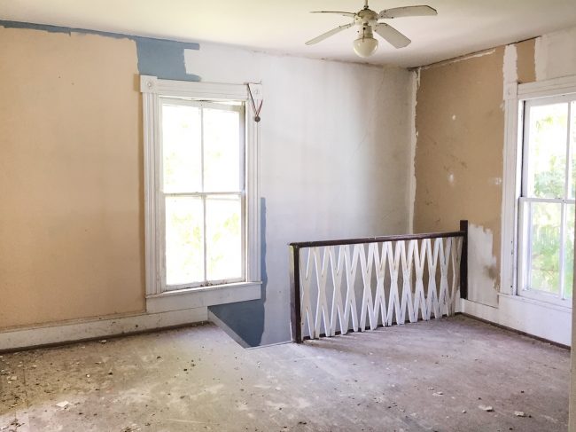 Before Photo Of Beach House Back Bedroom With Unpainted Walls and X Railing On Stairs