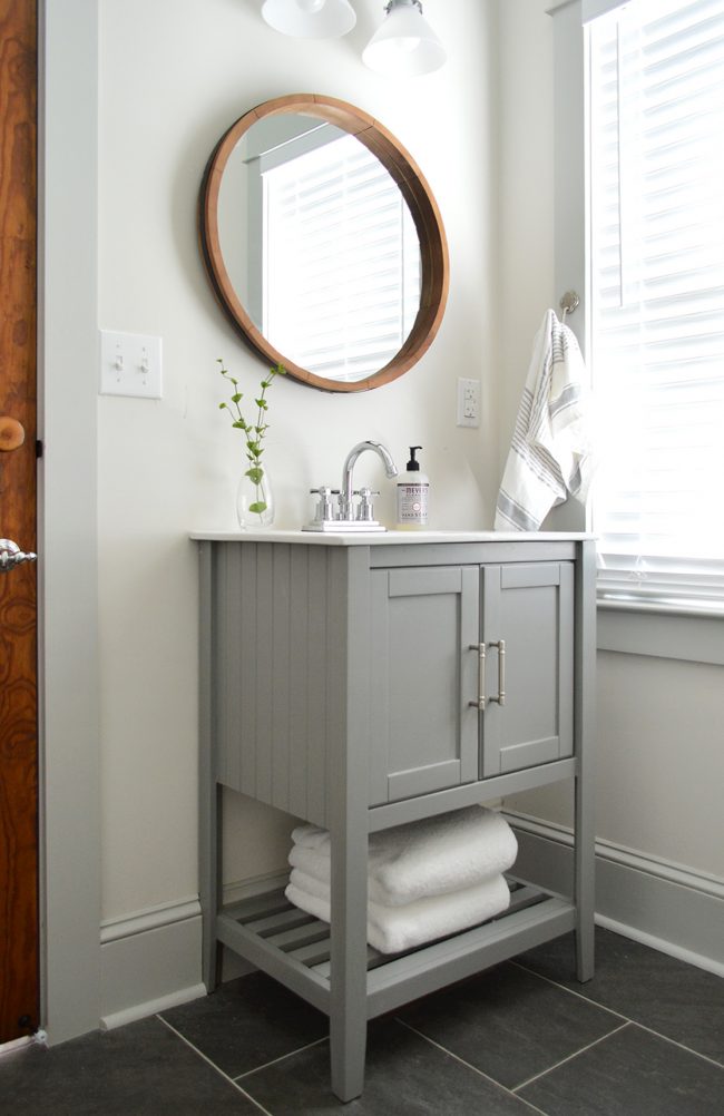 Gray Vanity In Beach House Downstairs Bathroom With Wood Circle Mirror