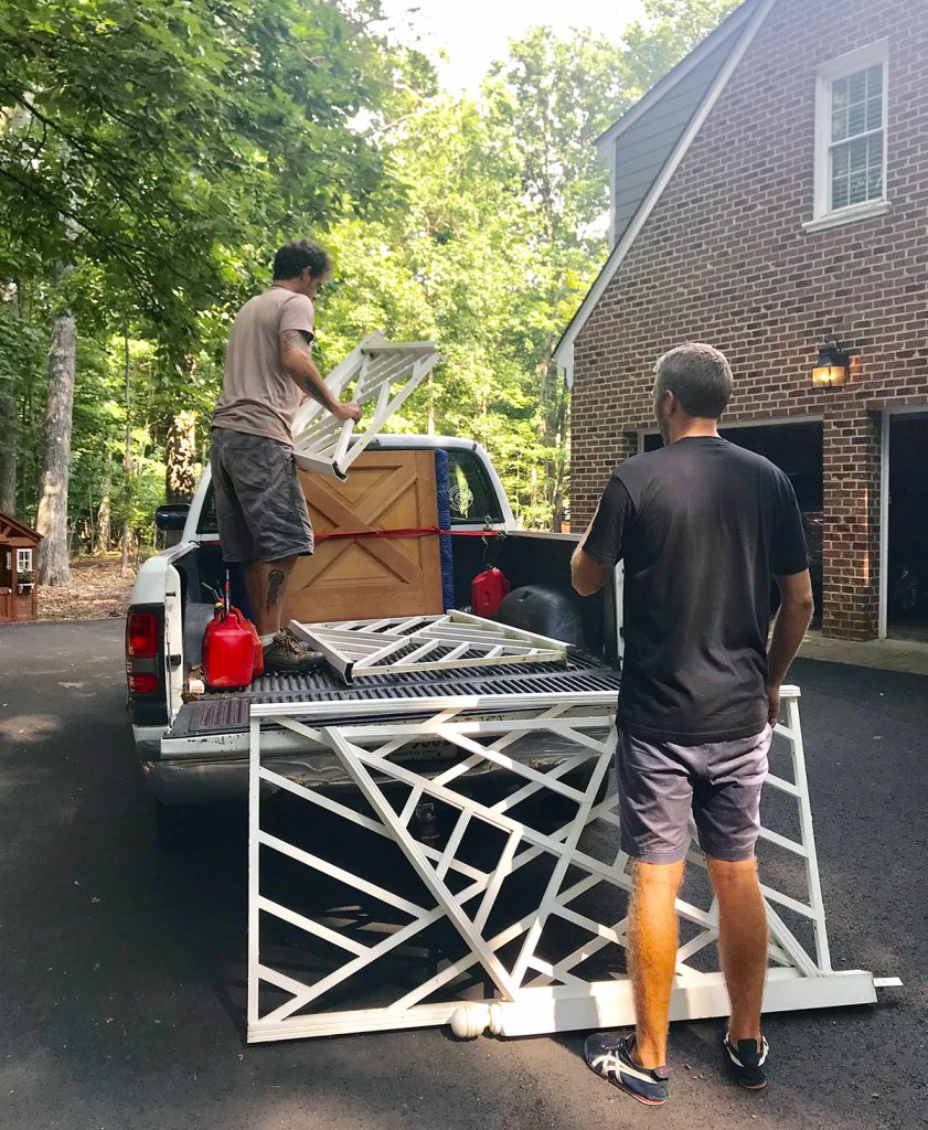 John loading large railings into a pick-up truck