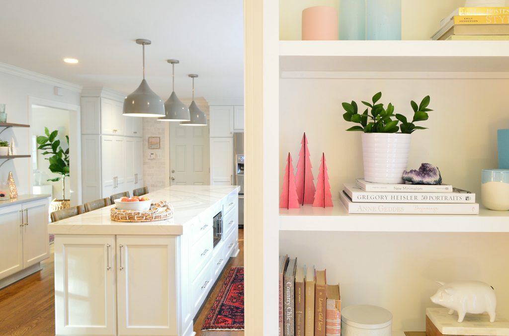 Plant on built-in bookcase in living room with kitchen in the background