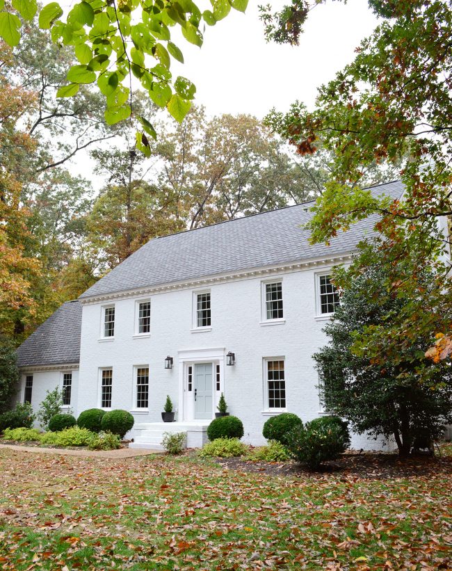 after photo of brick house painted moderne white with tranquility blue door