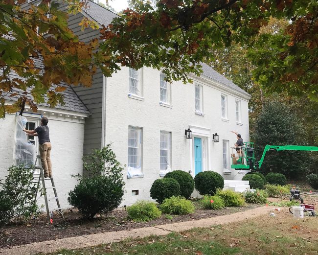 painters applying second coat of romabio biodomus paint to brick house