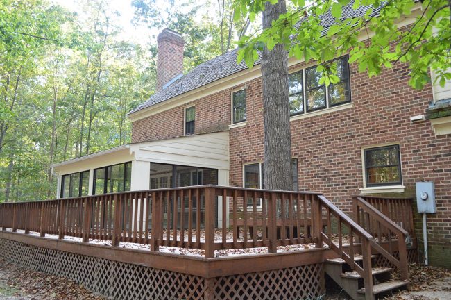 before photo of back of brick house with large deck