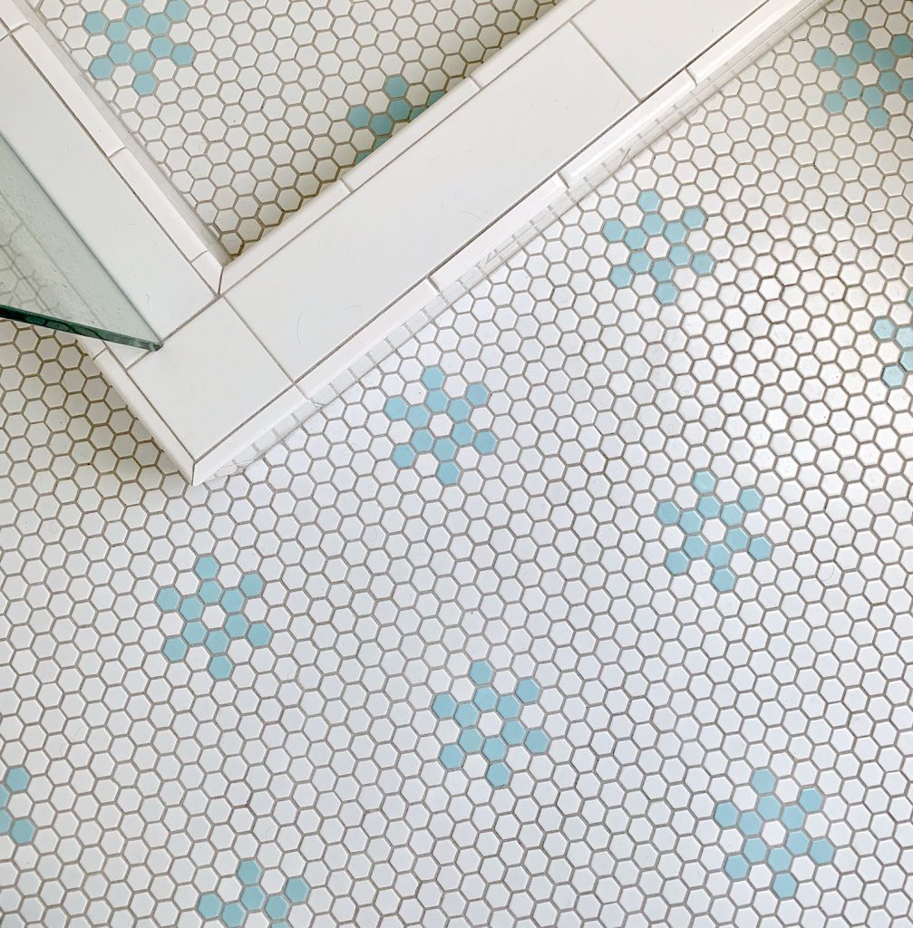 Hex tile bathroom floor with aqua blue flower shapes