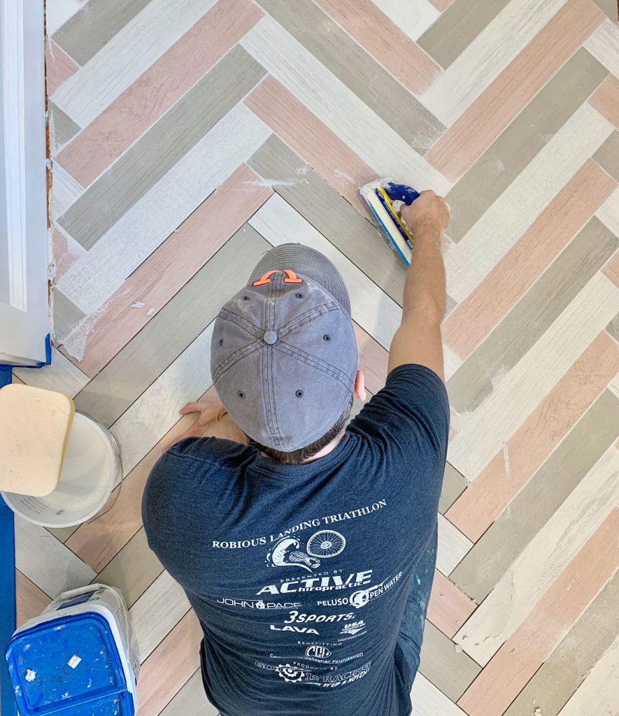 John grouting a colorful herringbone mudroom floor with mapei grout