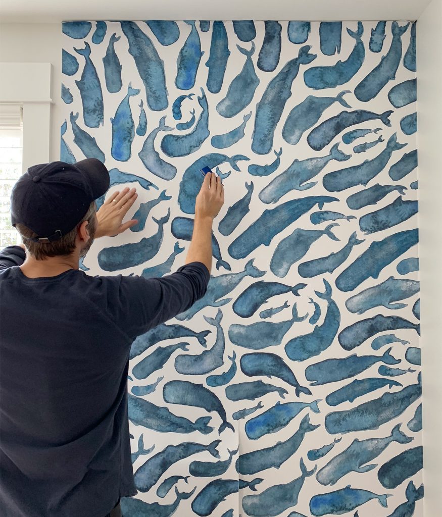 Instalação do segundo painel de papel de parede removível Whale suavizando os vincos