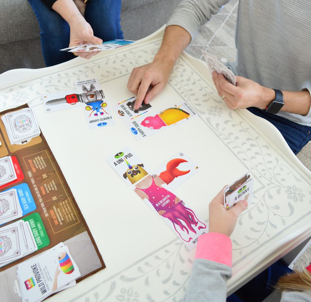 hands playing bears vs babies board game on stenciled coffee table