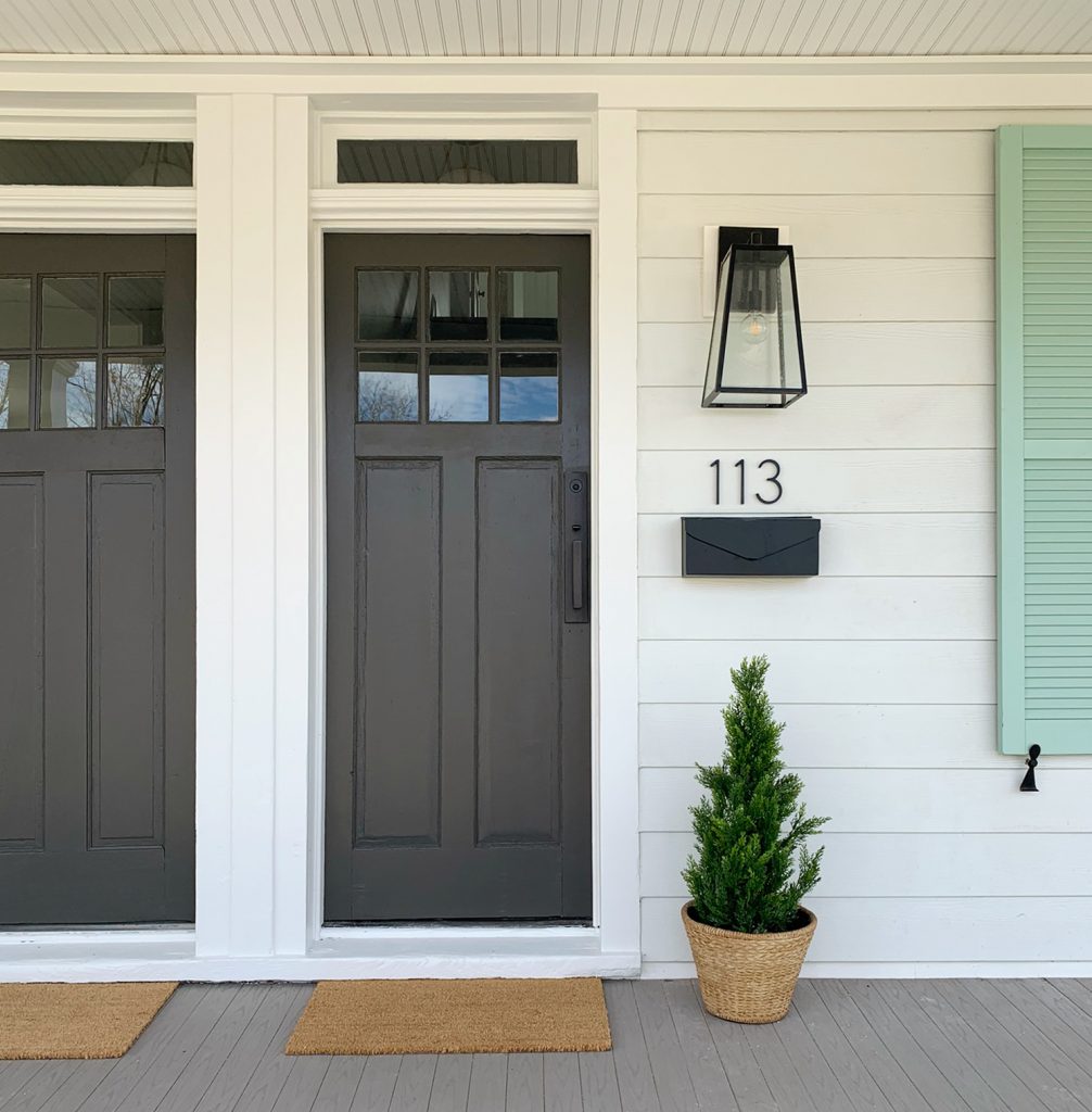 One Side of Duplex Front Porch With 113 House Number And Fake Plant