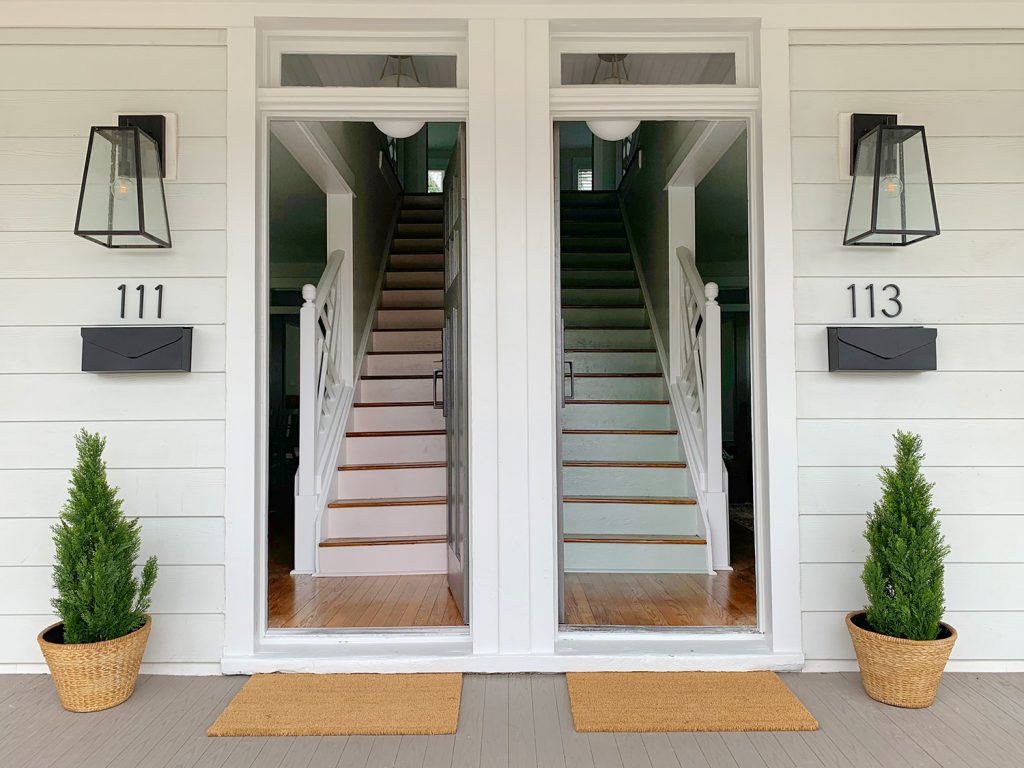 Escadas coloridas duplex: uma pintada de rosa e outra de azul e verde com números de casas