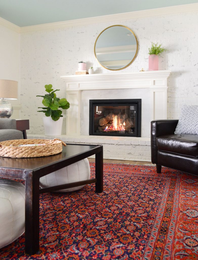 Faux greenery in living room with white walls and red vintage rug