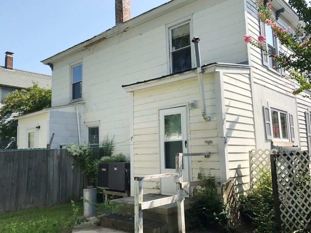 After Photo Of Back of Duplex With Rotting Siding And Wood Railings