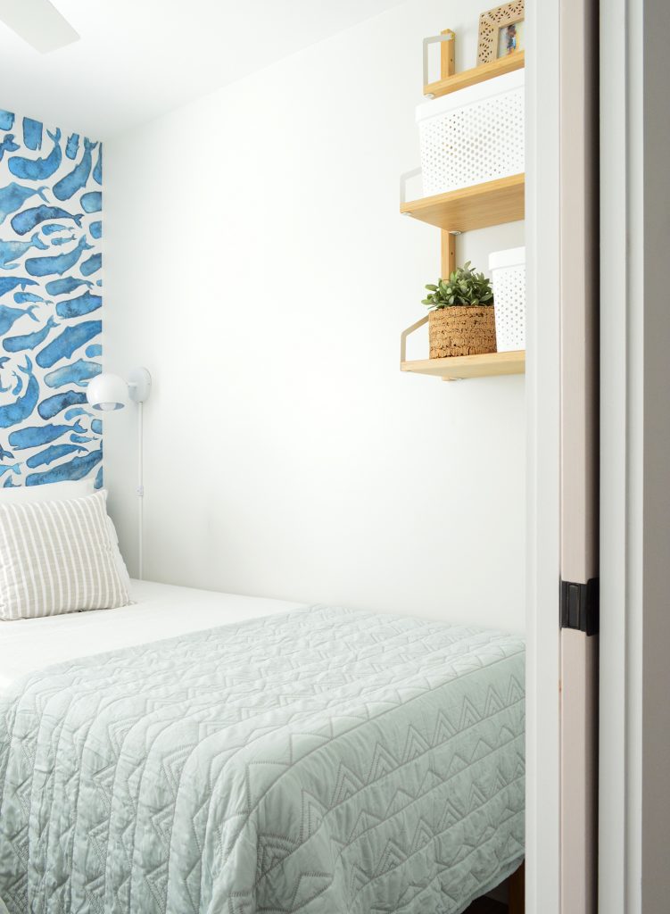 Small Twin Bed Room With Blue Bedding And Wood Wall Shelf