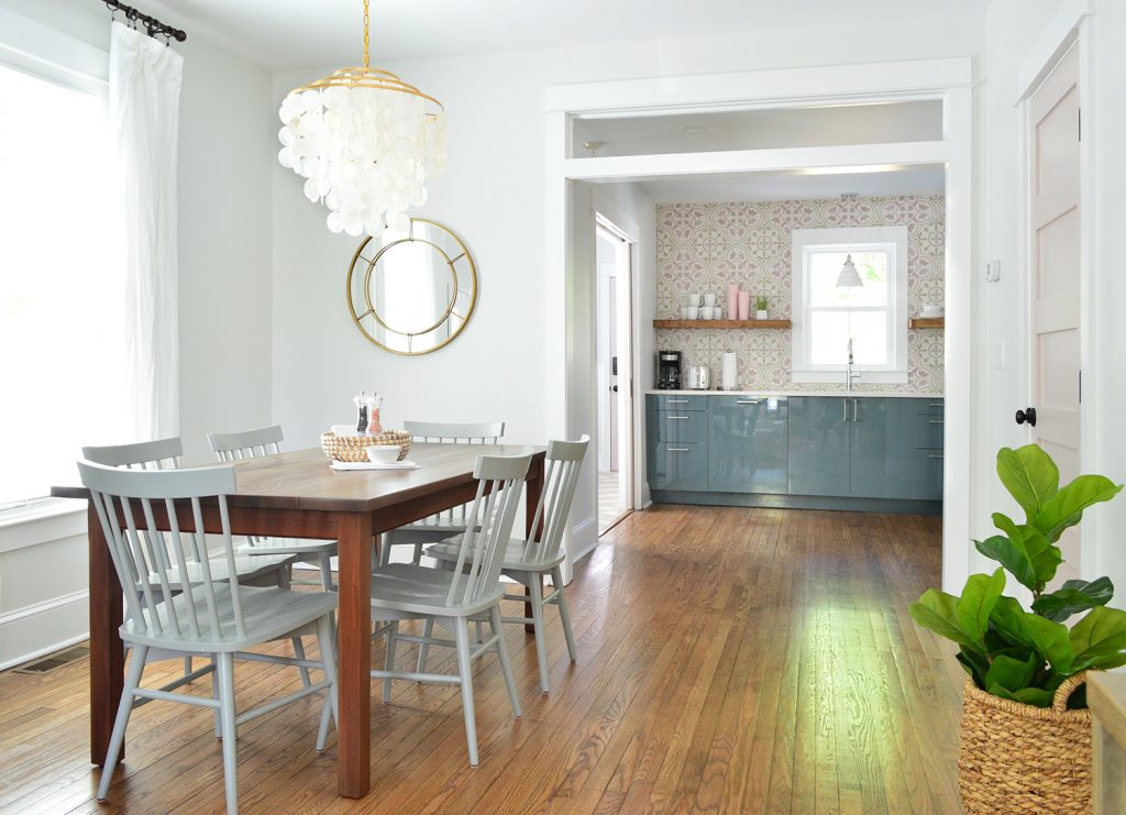 Bright Dining Room With Capiz Chandelier Looking Into Pink And Blue Kitchen