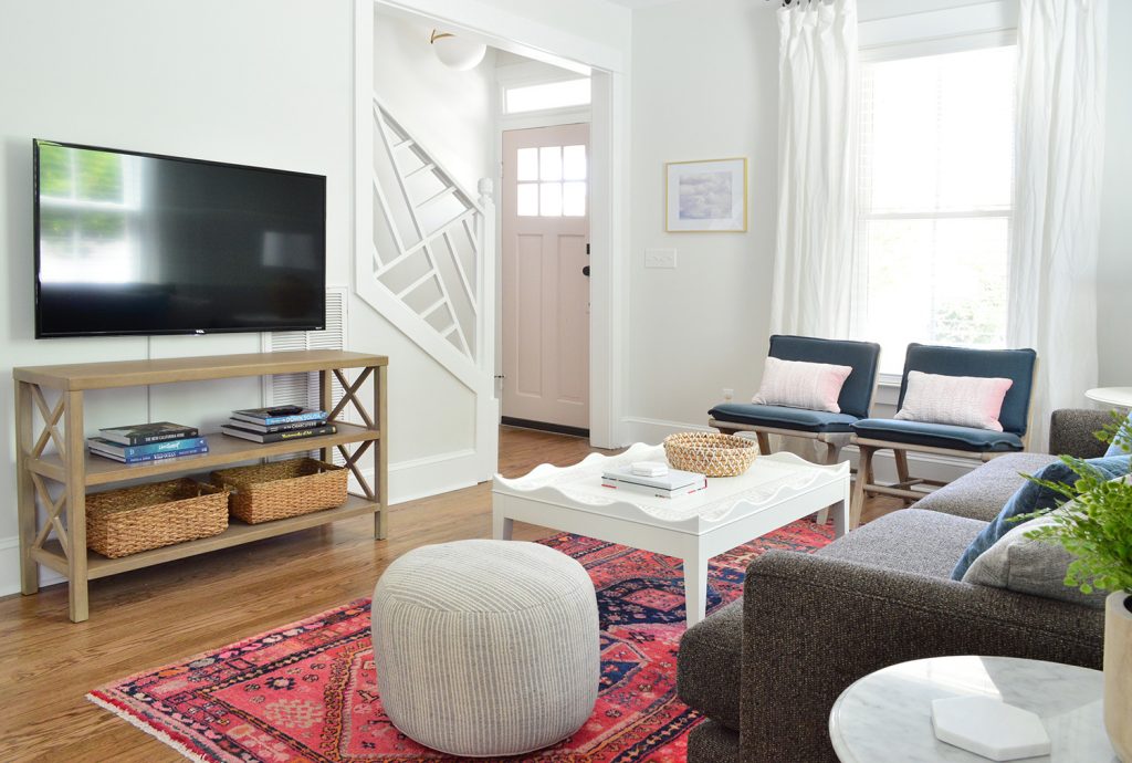 Bright Beach House Living Room With Pouf And Chippendale Stair Railing