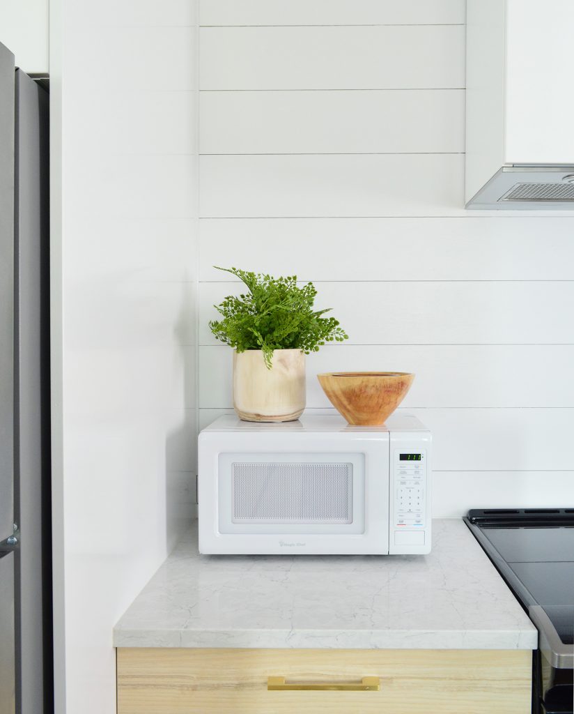 Detail Of Planked Wall In Duplex Kitchen With Counter Microwave