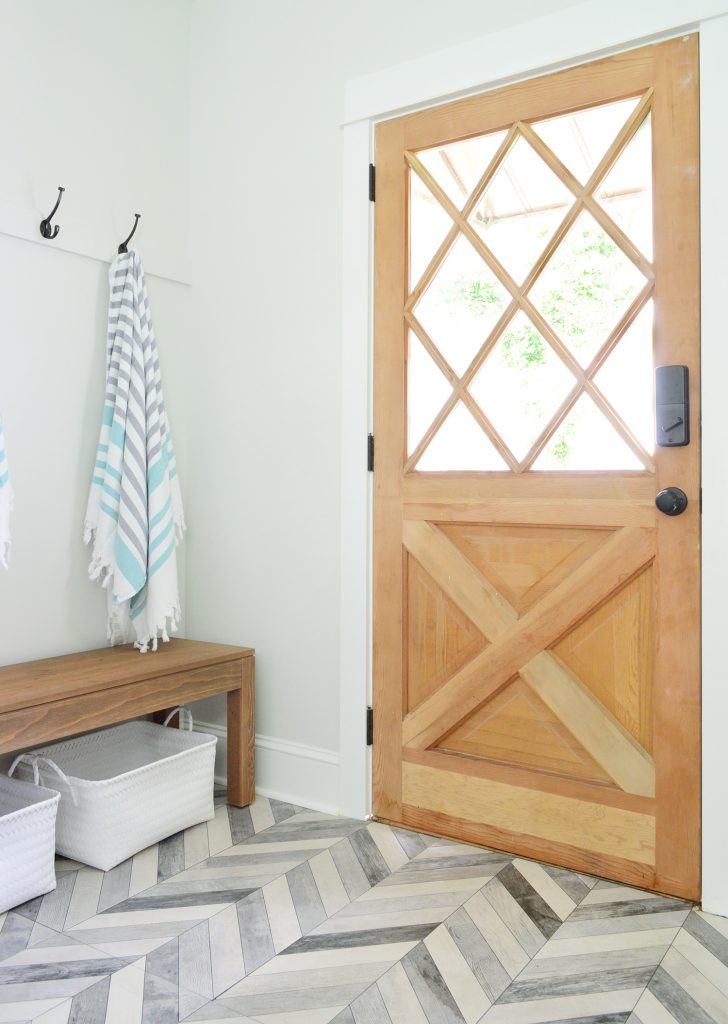 Diamond Paned Wood Door With Bench And Hooks In Duplex Mudroom