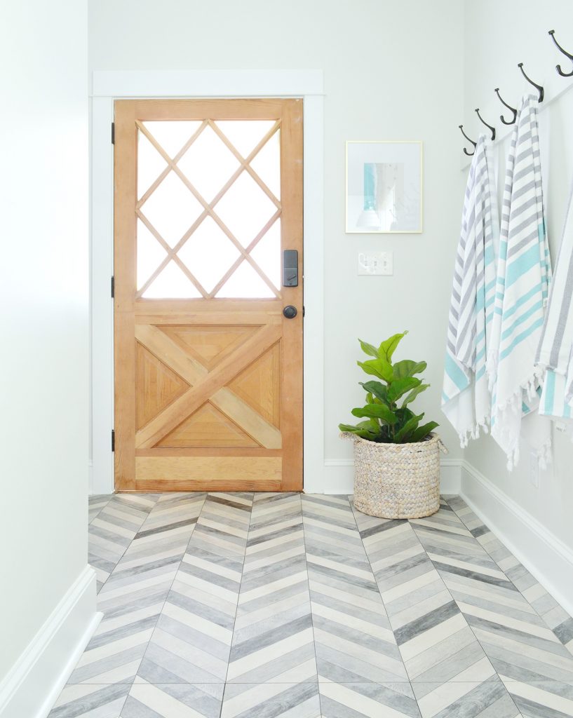 Porta de madeira com vidro diamantado no Mudroom duplex com piso Chevron