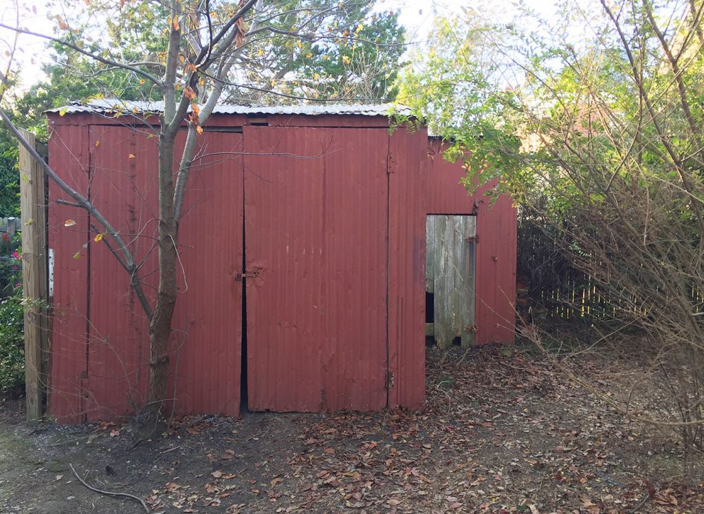 Before Photo Of Rusted Metal Shed In Beach House Backyard