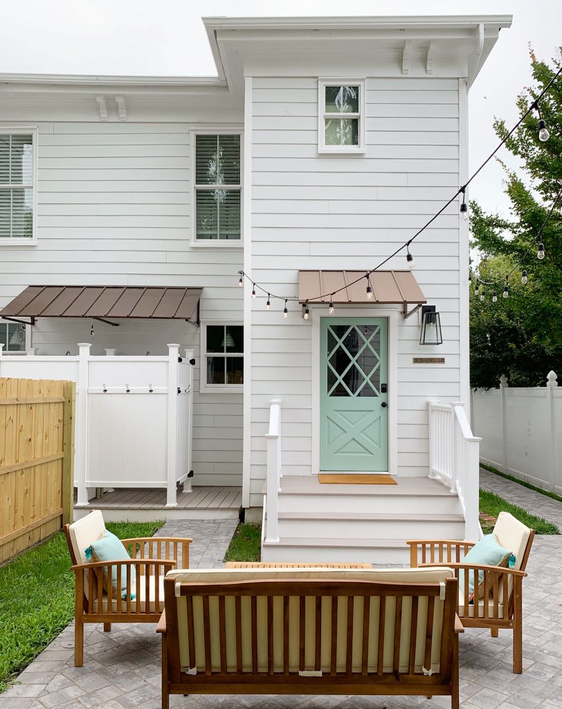 Rear Of Duplex With Mint Pale Patina Colored Doors With X Grid Pattern And Tin Awnings