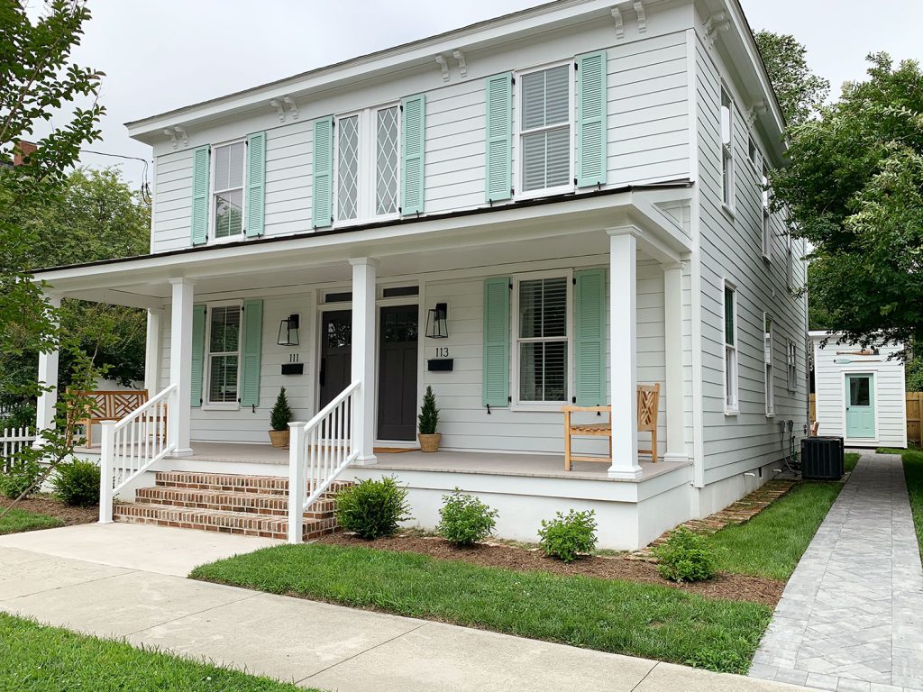 White Historic Duplex Home With Mint Green Shutters And Wide Open Porch