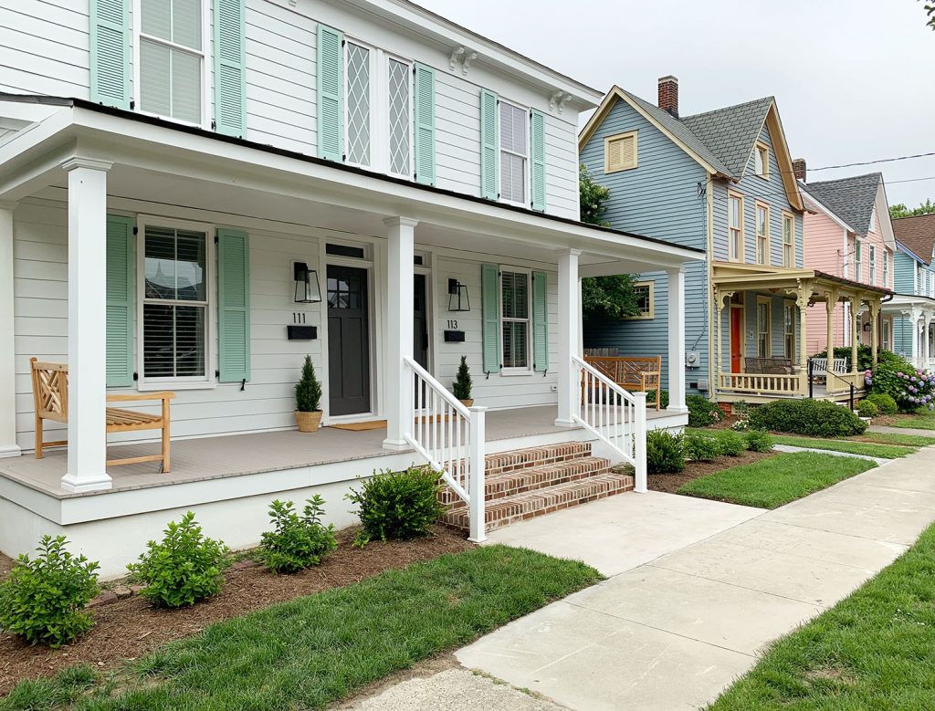 Historic Duplex Home In Cape Charles VA With White Siding Mint Shutters Seen Down Street