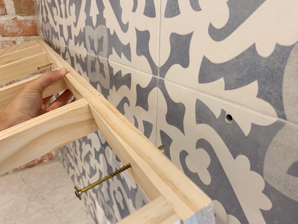 Holes In Tile Backsplash Where Shelf Support Bracket Is Being Placed