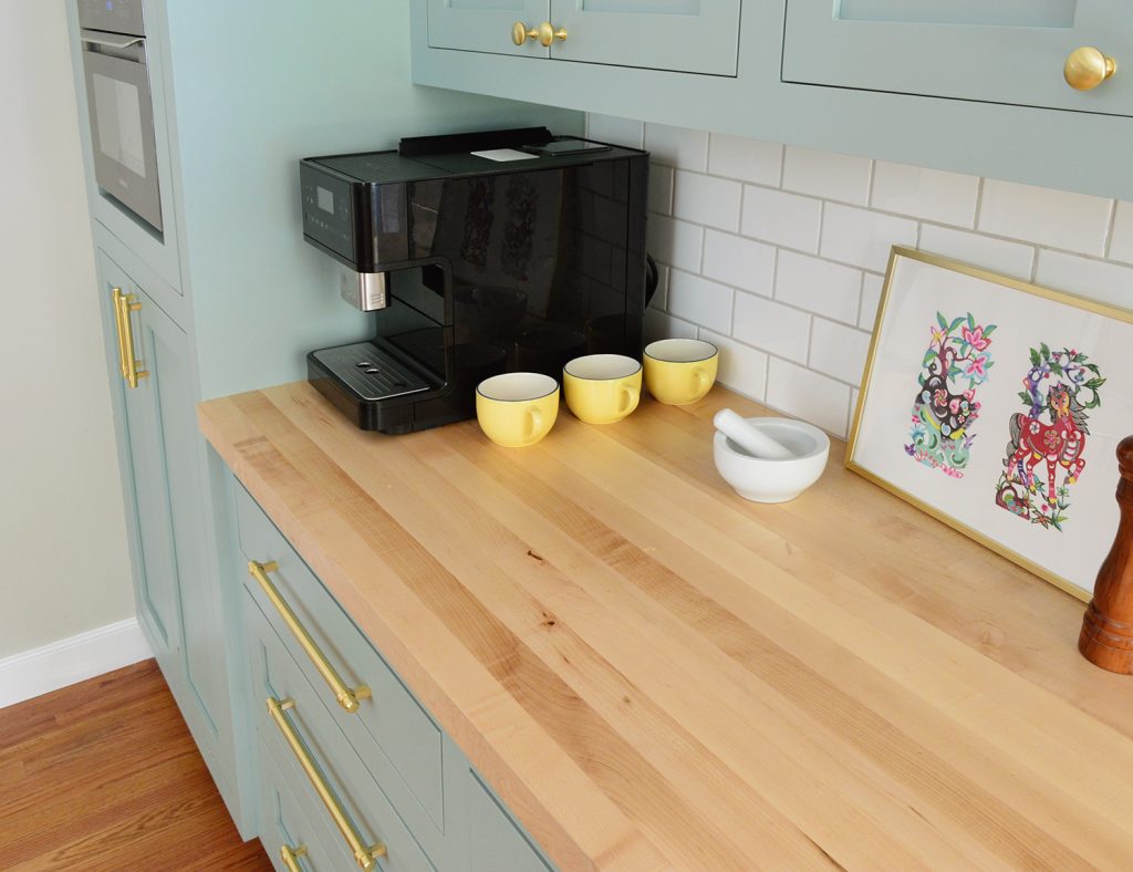 Bancada de bloco de açougueiro com backsplash de azulejo de metrô na cozinha azul verde Halcyon