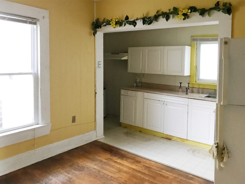 Before Photo Of Galley Style Kitchen With White Cabinets and Yellow Trim