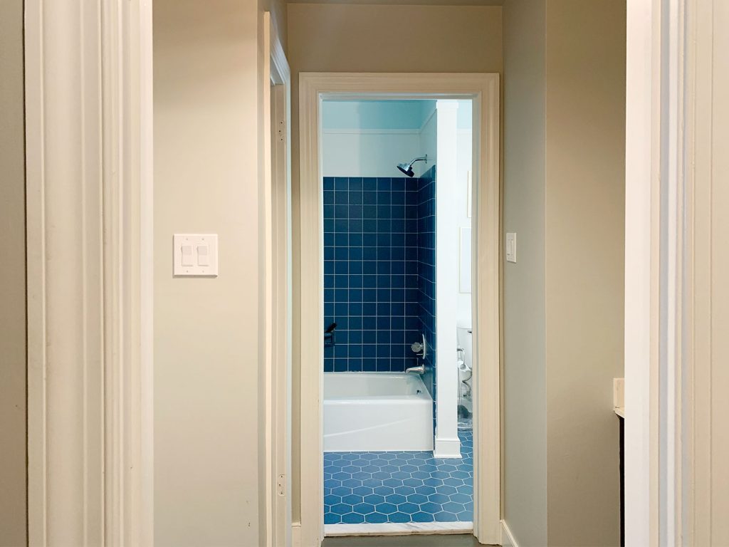 Before Photo Of Bathroom With Blue Tile And Wall Separating Space