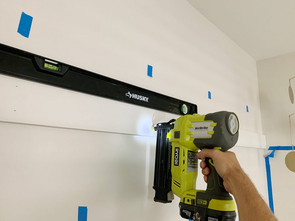 Using Nail Gun To Install Top Rail Of Board And Batten