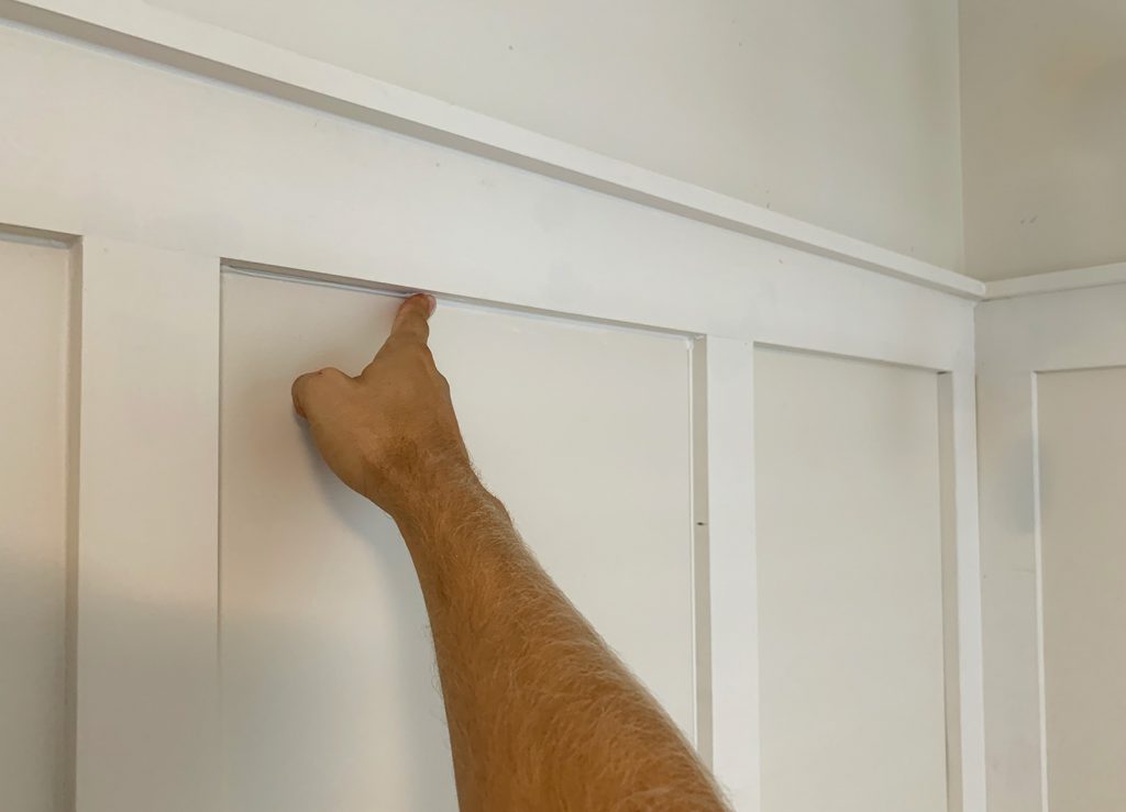 Finger Wiping Caulk Smooth Along Seams In Board And Batten