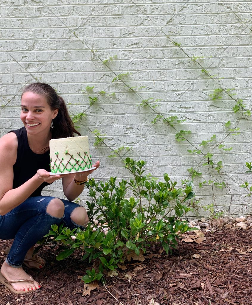 Sherry posing next to wire trellis with vine decorated cake