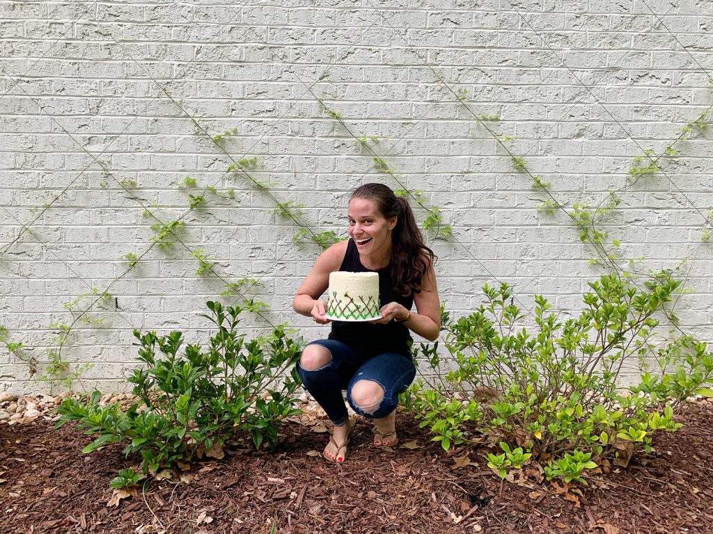 Sherry posing in front of vine diamond trellis with matching cake