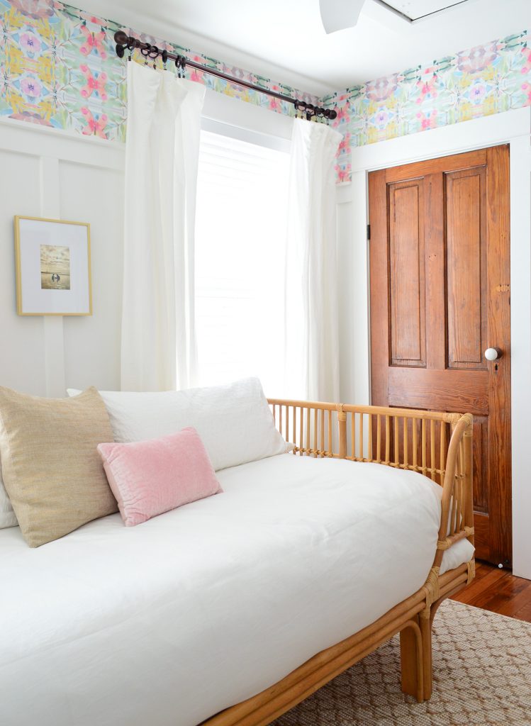 Rattan Daybed With White Bedding In Room With Wood Doors