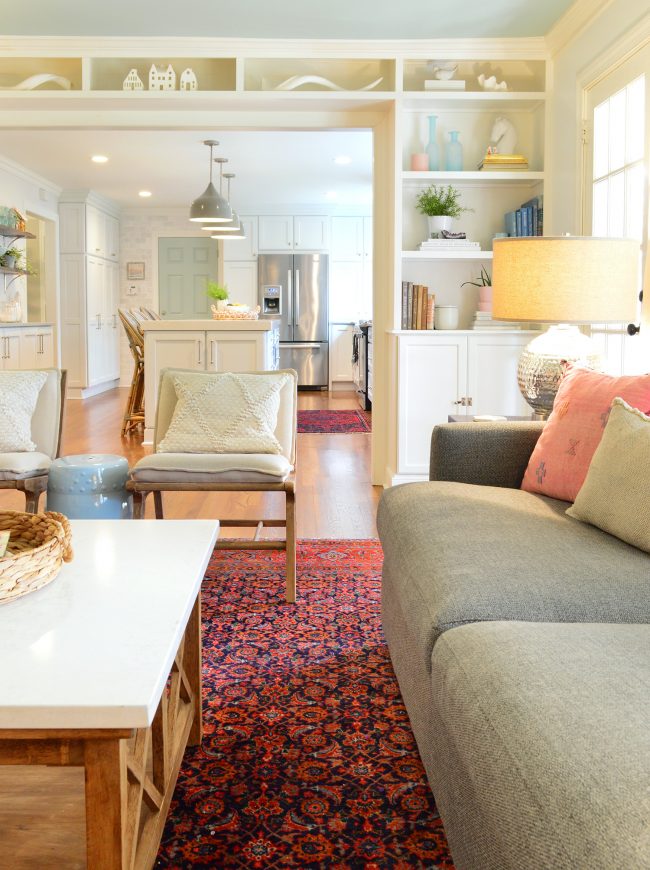 After Photo Of Traditional Living Room With White Build-In Shelves Around Opening To Kitchen