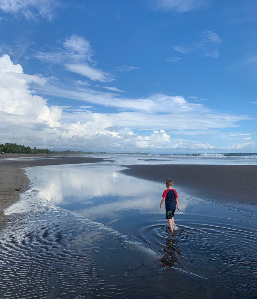 Young Boy Playing In Tide Pool at Esterillos Oeste Beach In Costa Rica