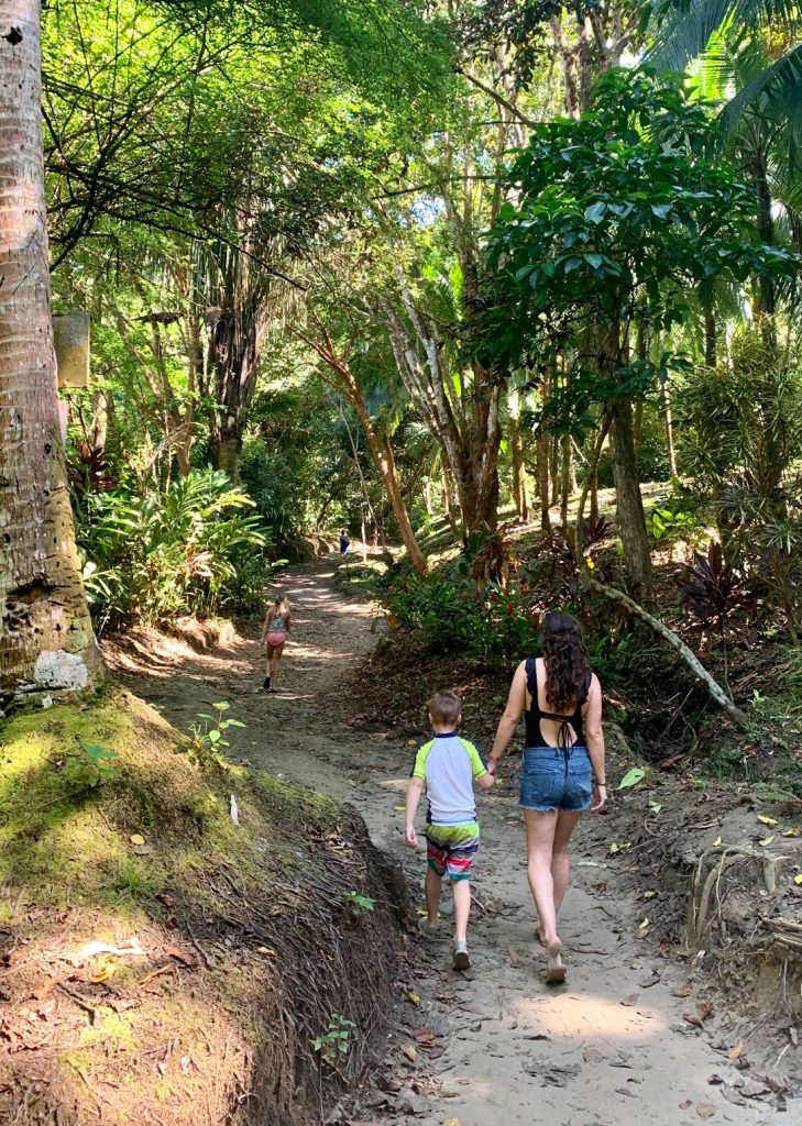 Mom Walking With Young Kids To Secret Playa Biesanz Beach In Costa Rica