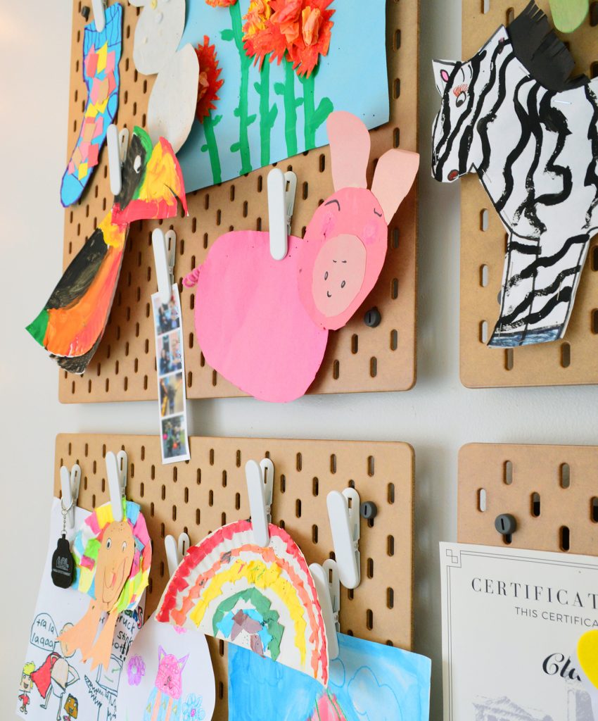 Ikea Skadis Pegboard Organizer With Kids Artwork Clipped Up For Display