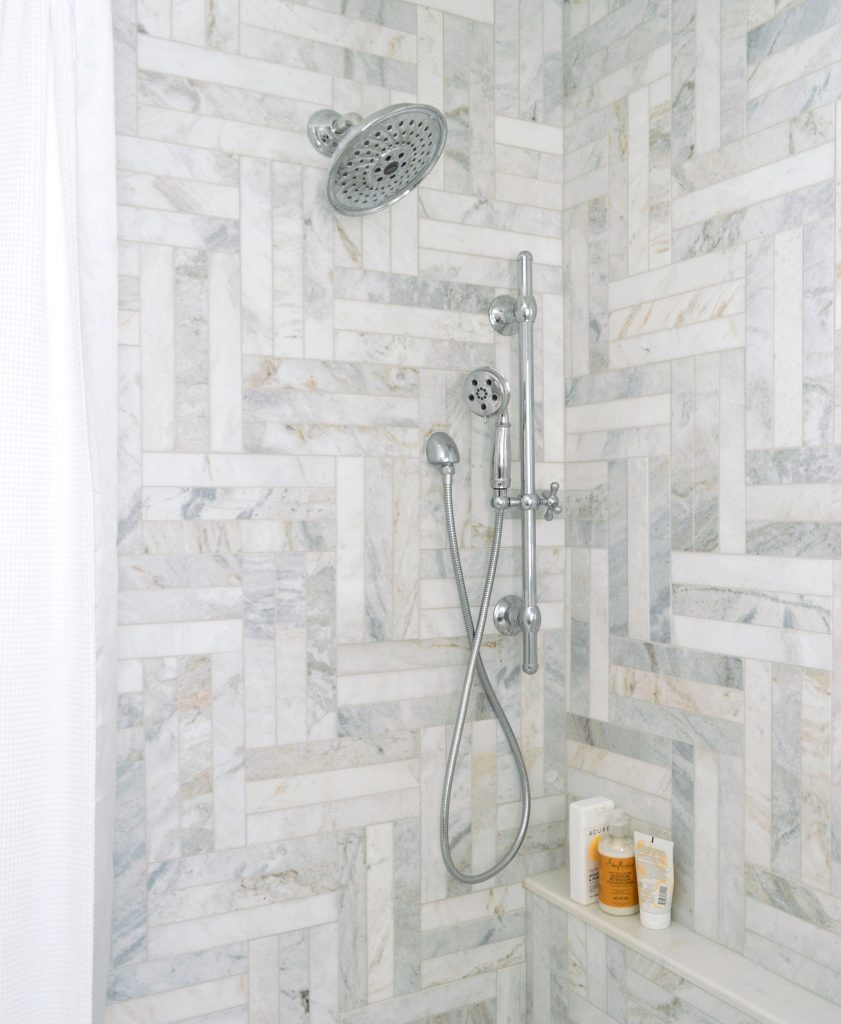 Chrome Delta Shower Fixtures In Walk-In Marble Herringbone Shower