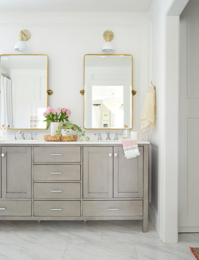 Traditional Gray Double Vanity In Bathroom With Brass Pivot Mirrors And Shades Of Light Dapper Sconce