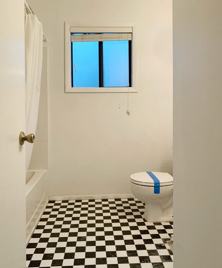 Before photo of bathroom with checkerboard floor and broken toilet