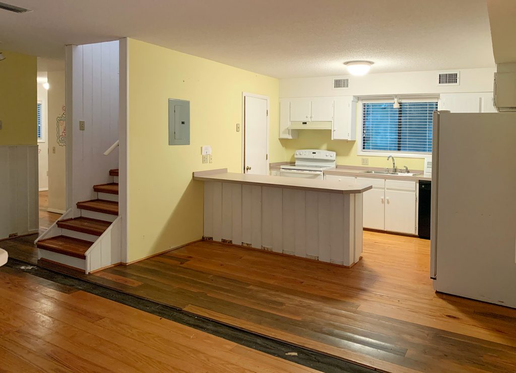 Before Photo Of Minimal Kitchen With Yellow Walls and Missing Floor Boards