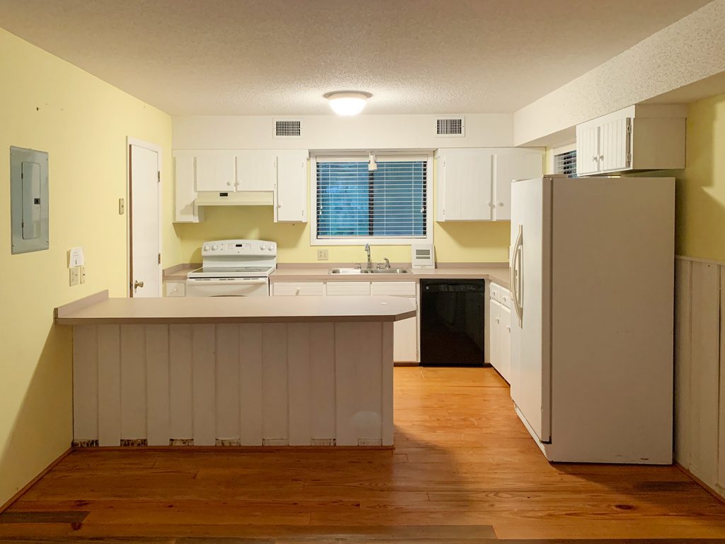 Before photo of kitchen with yellow walls and soffit