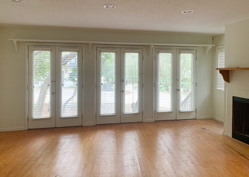 Before photo of bedroom as living space with wall of french doors