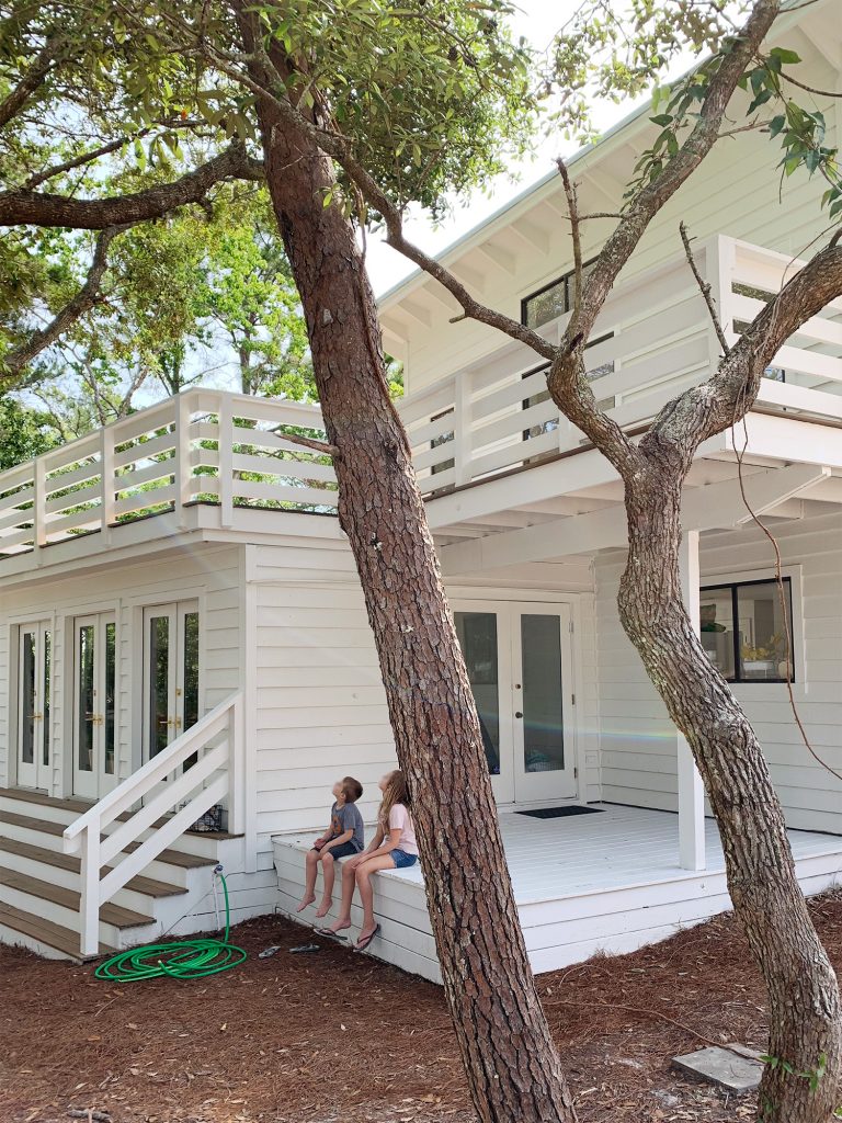 Covered white porch on move-in day with kids sitting on stoop